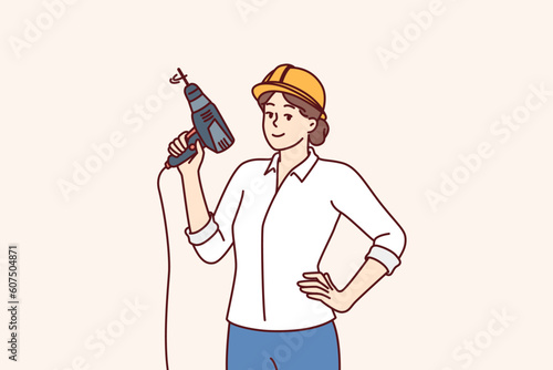 Woman with electric drill and hardhat for construction work or renovation premises is dressed in formal clothes. Girl foreman or construction company manager posing with equipment to create holes