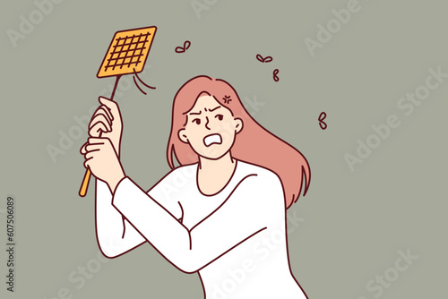 Angry woman kills mosquitoes using swatter feeling irritated due to insects disturbing sleep on summer night. Girl with swatter is annoyed by camaras and maskites and needs electric fumigator