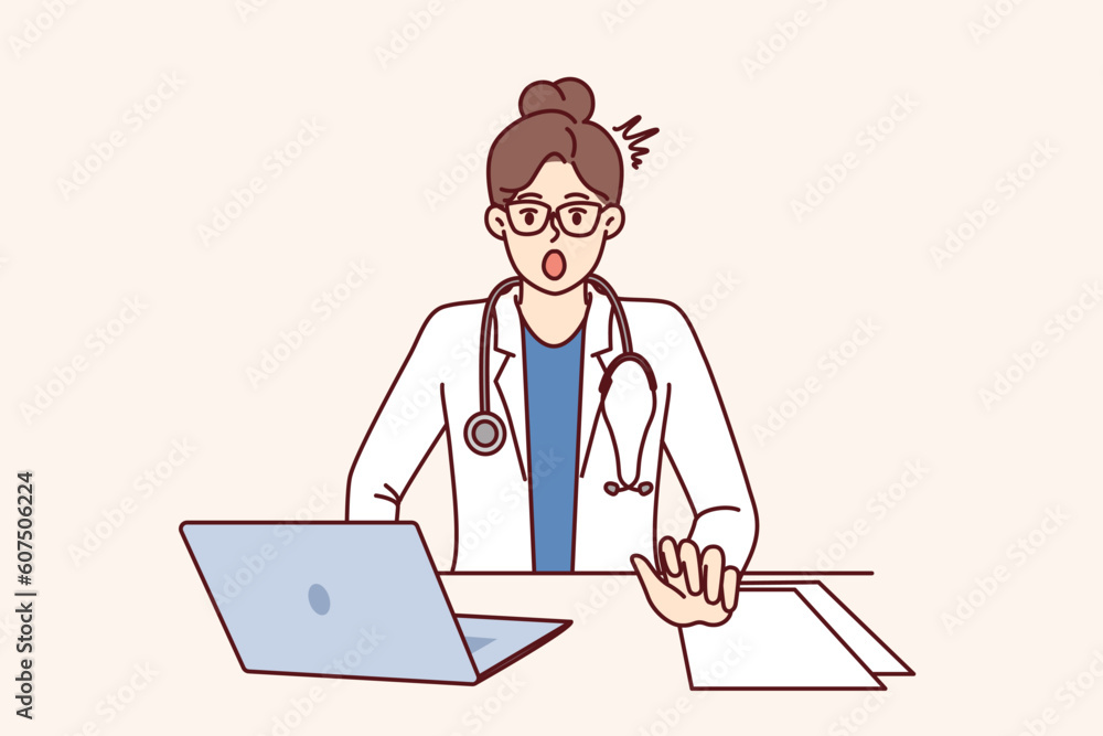 Shocked woman doctor is surprised to see rare disease, sits at table with laptop. Girl doctor with stethoscope, opening mouth looks at screen after learning about symptoms of mysterious disease Shocked woman doctor is surprised to see rare disease, sits at table with laptop. Girl doctor with stethoscope, opening mouth looks at screen after learning about symptoms of mysterious disease
