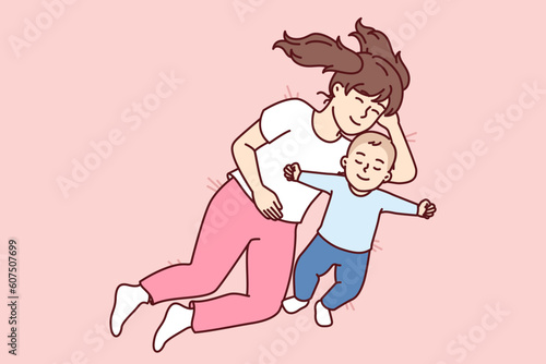 Little girl hugging newborn brother lying in bed and falling asleep together for happy childhood concept. Caring preteen sister near carelessly sleeping little toddler resting after day walk