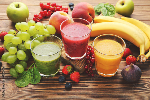 Murais de parede Healthy smoothie in glasses with fruits and vegetable on wooden background