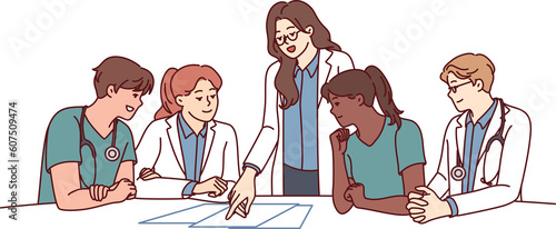 Clinic staff meeting, with doctors sitting at table and head physician giving instructions