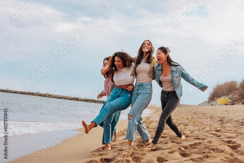 Four young women jumping together on beach