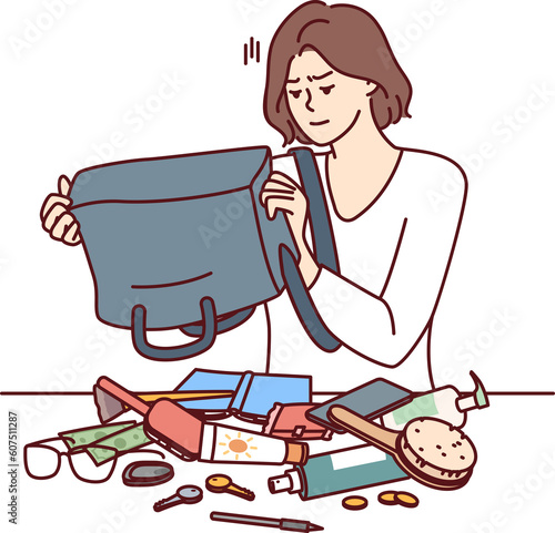 Quadro su tela Puzzled woman shakes out contents of bag on table trying to find wallet with mon