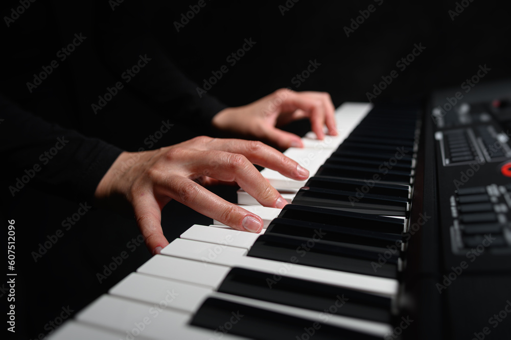 Playing a synthesizer on a dark background. The musician plays the synthesizer. Playing a synthesizer on a dark background. The musician plays the synthesizer.