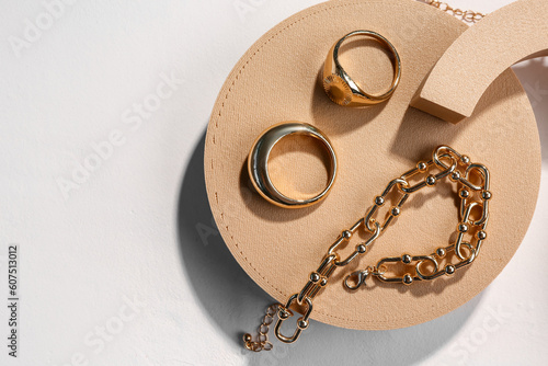 Decorative podiums with golden rings and bracelets on white background