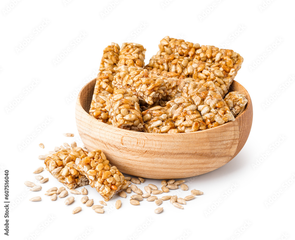 Bowl with tasty kozinaki and sunflower seeds on white background