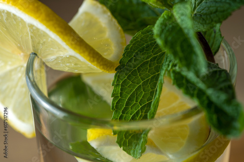 Lemonade fresh with lemon slices and mint leaves in glass close-up