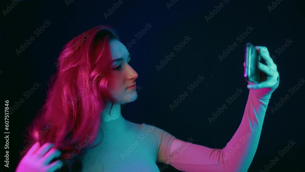 Fashion hipster cool girl taking self-portrait on smart phone while posing isolated over neon background, Fashion hipster cool girl taking self-portrait on smart phone while posing isolated over neon background,