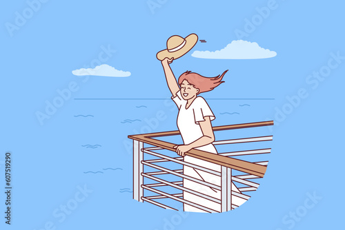 Woman tourist on cruise liner stands near side and waves hand rejoicing at summer travel across ocean. Happy girl rejoices in freedom and opportunity to travel on sea yachts between tropical islands