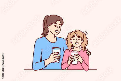 Mom and daughter drink natural milk to get useful vitamins and lactose or calcium from eco product. Woman hugging smiling teenage girl drinking milk to promote healthy food without chemicals