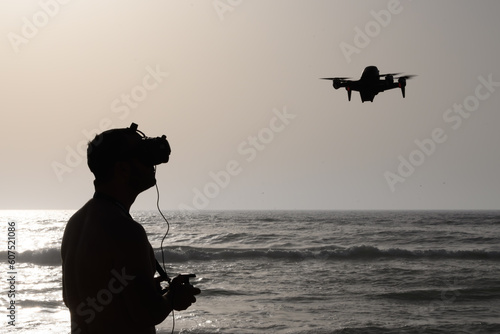 person flying a drone on the beach