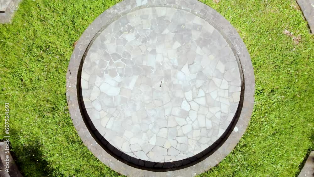 Vista aérea alejándose de una pileta rodeado de un bosque verde con arboles de ciprés y palmeras en una hacienda antigua.