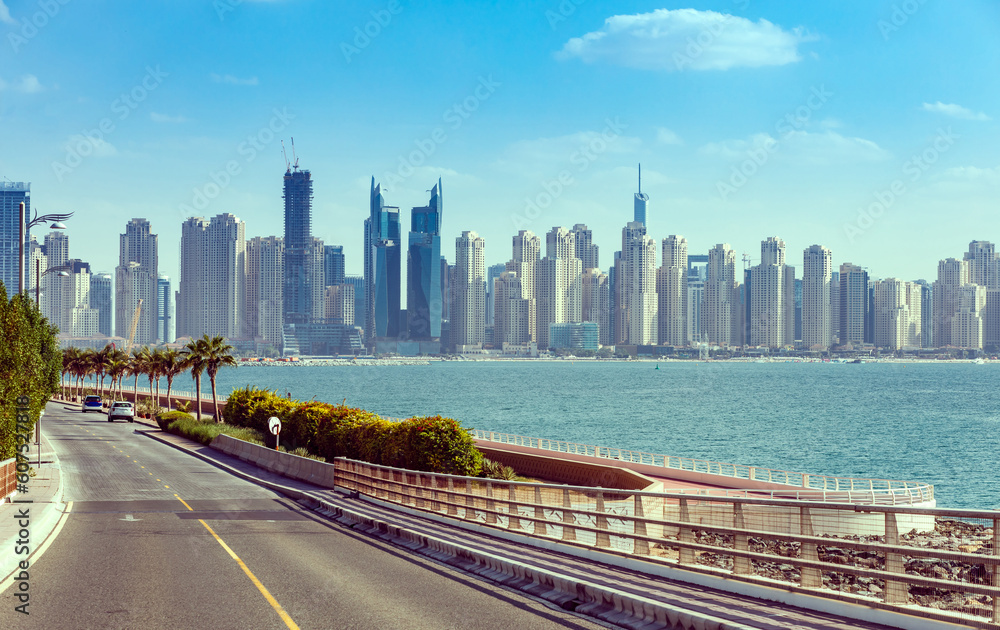 View of Dubai with palm trees and skyscrapers. Sunny summer day in UAE