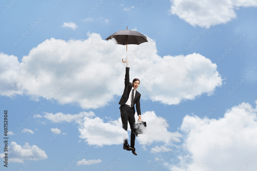 Businessman holding an umbrella and flying in the sky Businessman holding an umbrella and flying in the sky