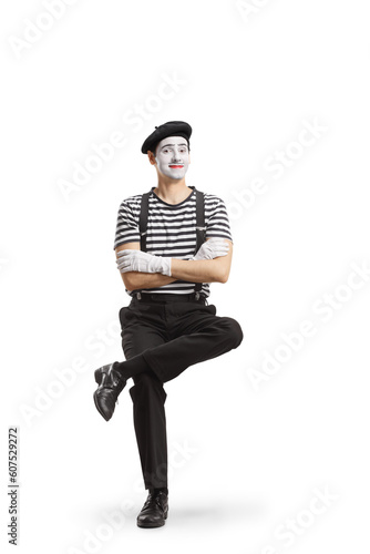 Full length portrait of a mime sitting on an invisible chair