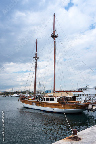 Beautiful wooden yacht moored in marina and bollard in the foreground. Vacation and tourism concept 