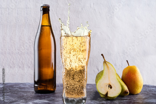 Drink bottle and glass. Carbonated water in a glass. Splashes from a glass. Pears and apples near the glass. photo