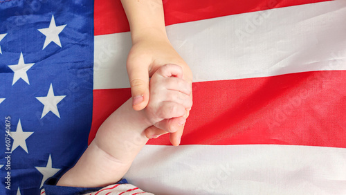 USA Independence Day. Children holding hands on the background of the flag of America
