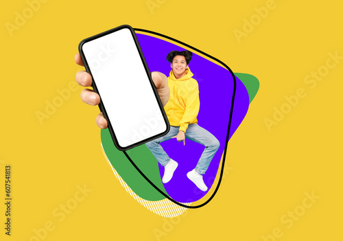 Photographie Cheerful Asian Teen Guy Jumping Up With Big Blank Smartphone In Hand