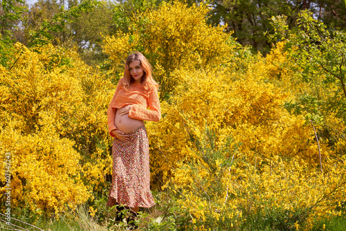 Young pregnant woman touching and looking at her belly and caring about her health.Pregnancy, maternity, preparation and expectation concept.Beautiful tender mood of pregnant woman.Young mom.      