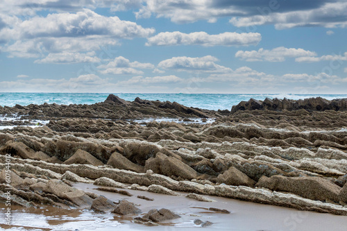 VIEW of Flysch sticking out of the sand on the shore of Itzurun beach,Zumaia,Guipuzcua,Spain photo