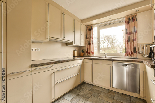 Fototapeta Naklejka Na Ścianę i Meble -  a kitchen with white cabinets and silver appliances on the counter tops in front of the dishwasher, which has been used for