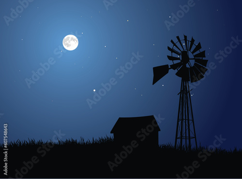 View of a rural farm silhouetted by the full moon.