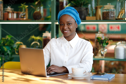 Happy african woman independent contractor working from cafe  copy space