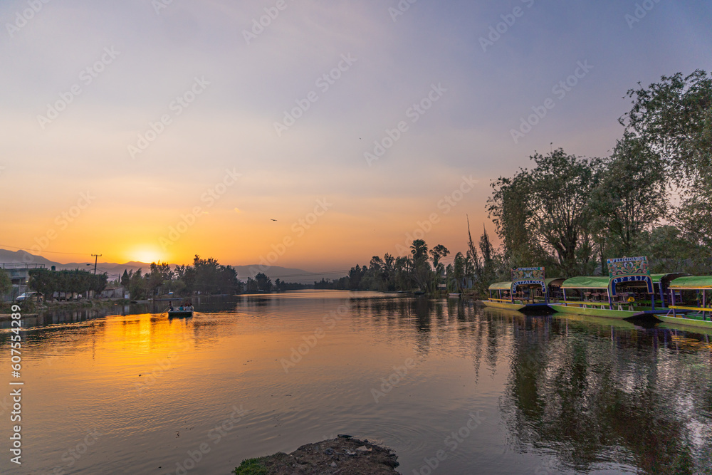 Hermoso atardecer en el lago de Xochimilco, trajineras de fondo. 