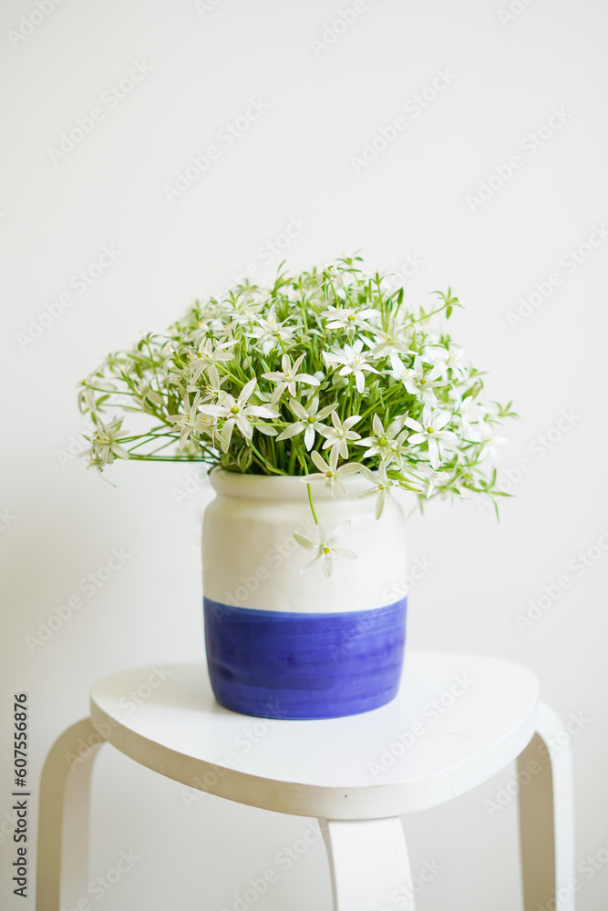A bouquet of white garden flowers in a vase on a light background A bouquet of white garden flowers in a vase on a light background