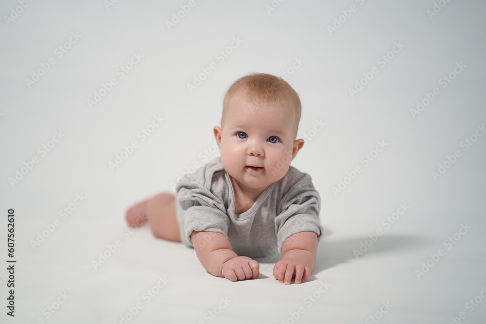 Portrait of a baby on a light background. baby lying on stomach Portrait of a baby on a light background. baby lying on stomach