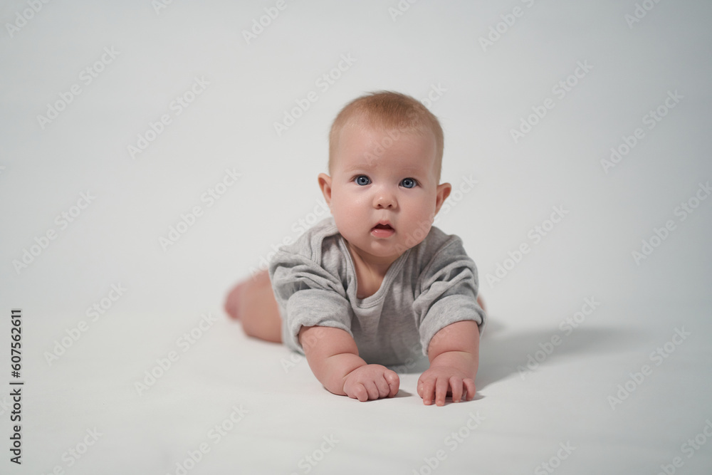 Portrait of a baby on a light background. baby lying on stomach Portrait of a baby on a light background. baby lying on stomach