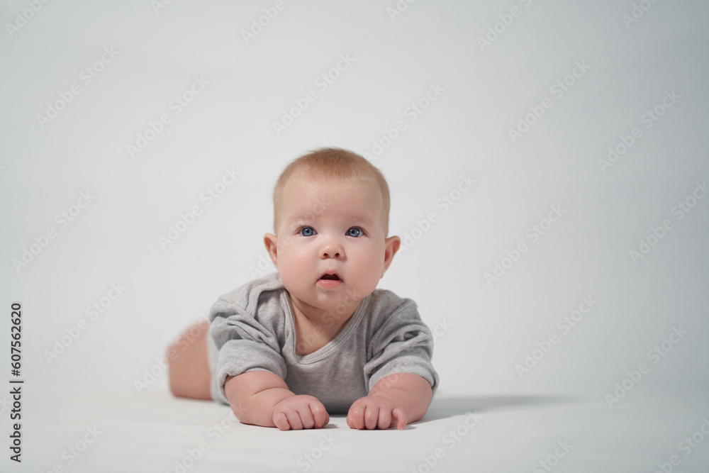 Portrait of a baby on a light background. baby lying on stomach Portrait of a baby on a light background. baby lying on stomach
