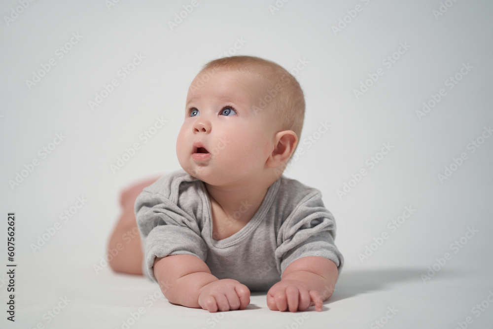 Portrait of a baby on a light background. baby lying on stomach Portrait of a baby on a light background. baby lying on stomach