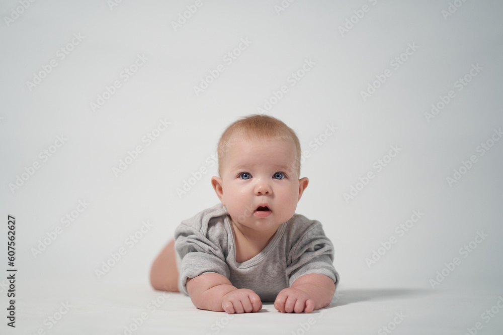 Portrait of a baby on a light background. baby lying on stomach Portrait of a baby on a light background. baby lying on stomach