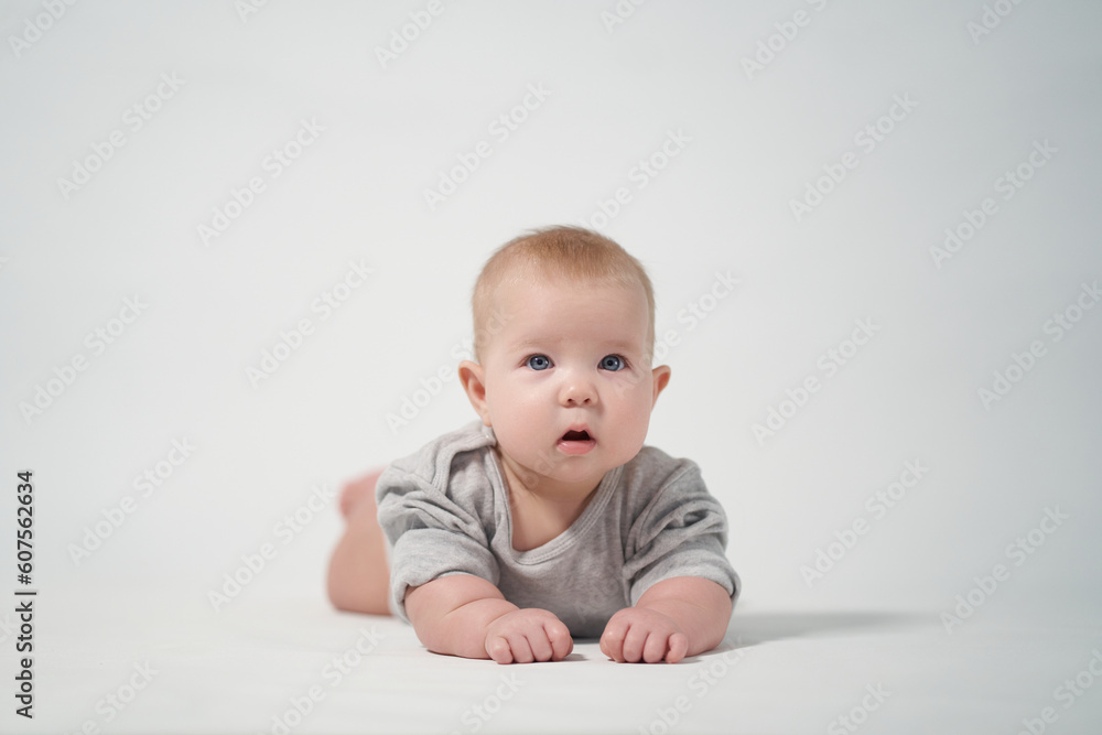 Portrait of a baby on a light background. baby lying on stomach Portrait of a baby on a light background. baby lying on stomach