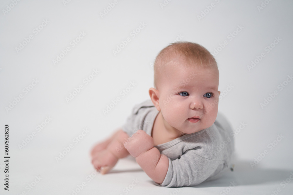 Portrait of a Baby in a gray jumpsuit, the photo was taken in a bright studio Portrait of a Baby in a gray jumpsuit, the photo was taken in a bright studio