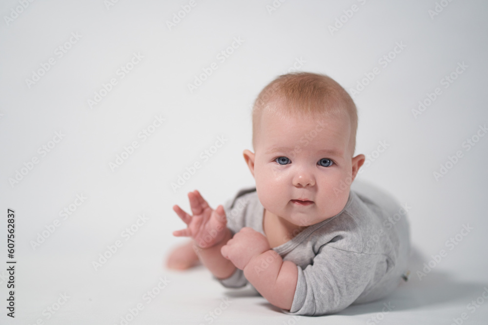 Portrait of a Baby in a gray jumpsuit, the photo was taken in a bright studio Portrait of a Baby in a gray jumpsuit, the photo was taken in a bright studio