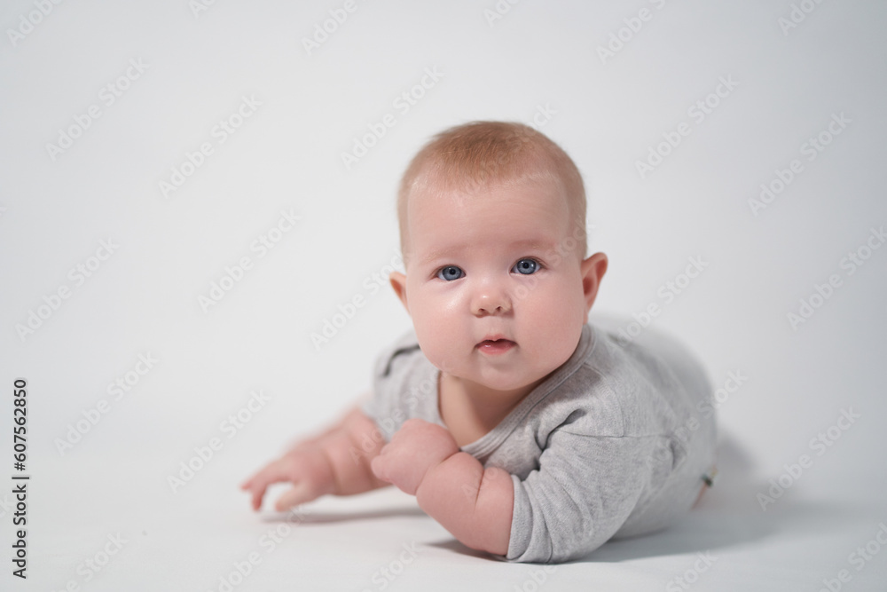 Portrait of a Baby in a gray jumpsuit, the photo was taken in a bright studio Portrait of a Baby in a gray jumpsuit, the photo was taken in a bright studio
