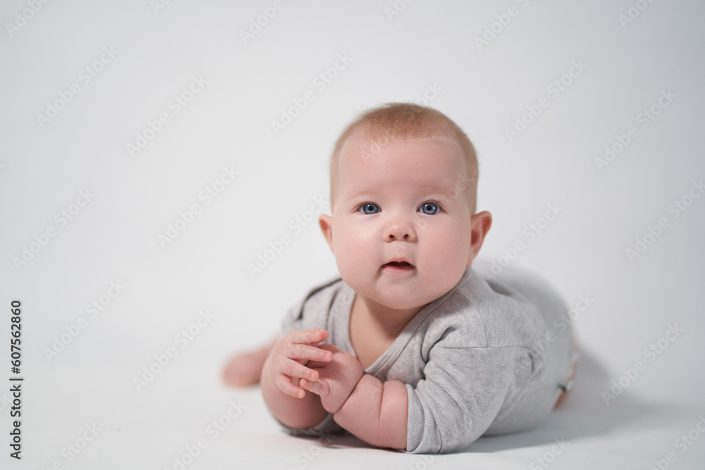 Portrait of a Baby in a gray jumpsuit, the photo was taken in a bright studio Portrait of a Baby in a gray jumpsuit, the photo was taken in a bright studio