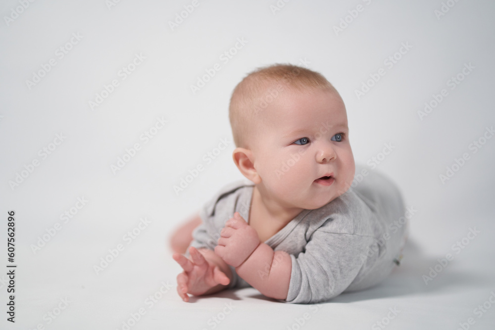 Portrait of a Baby in a gray jumpsuit, the photo was taken in a bright studio Portrait of a Baby in a gray jumpsuit, the photo was taken in a bright studio