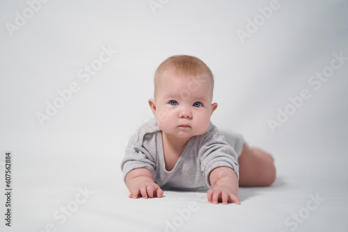 Portrait of a Baby in a gray jumpsuit, the photo was taken in a bright studio