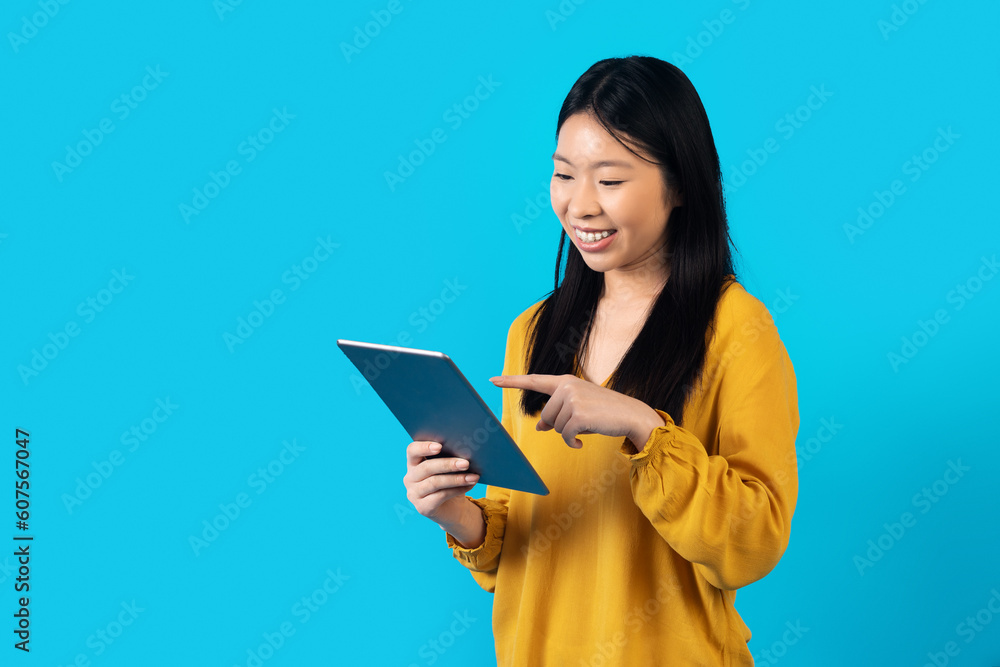 Happy asian lady enjoying her brand new digital tablet Happy asian lady enjoying her brand new digital tablet