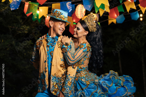 A professional Quadrilha dance couple, adorned in vibrant costumes, elegantly moves to the rhythmic beats at a lively Brazilian June party.