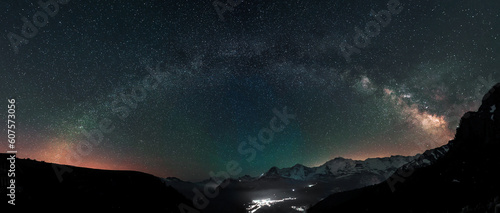 Milky Way arc and stars in night sky over the Swiss Alps with the famous alpen peaks Eiger, Monch and Jungfrau down right in the background photo