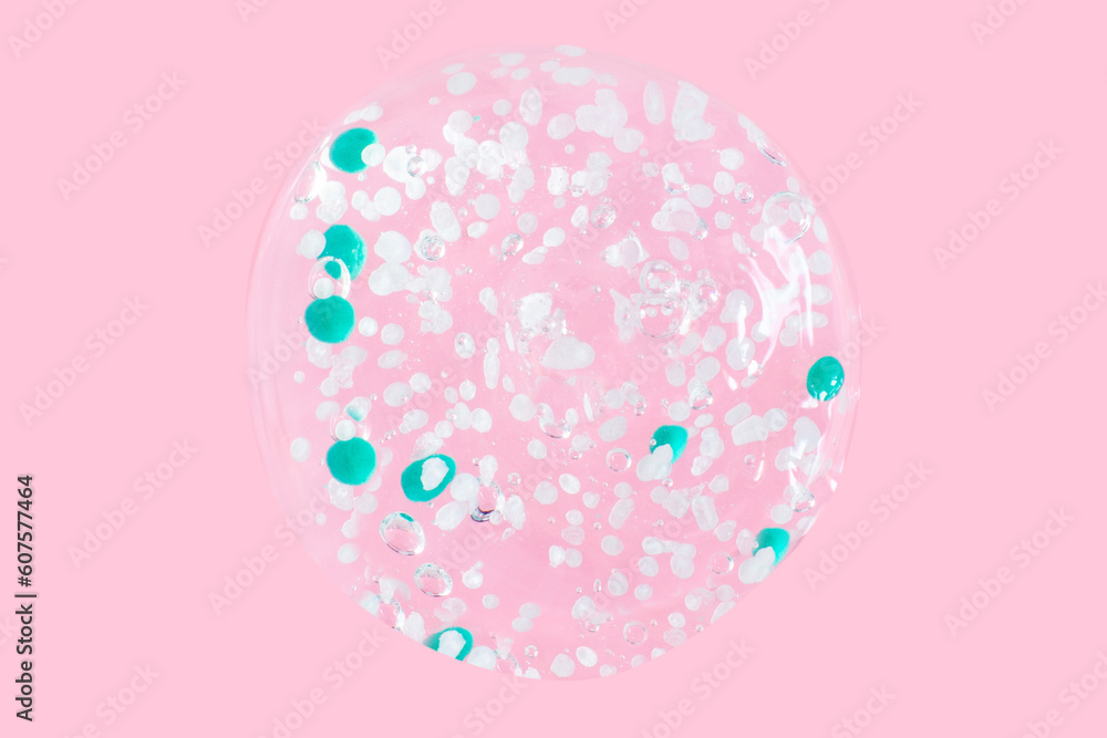smears and drops of transparent gel with blue granules. On a pink background. smears and drops of transparent gel with blue granules. On a pink background.