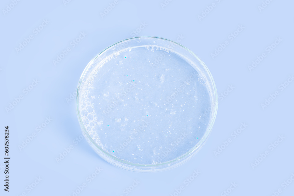 Facial Detergent in a Petri dish on a blue background. Facial Detergent in a Petri dish on a blue background.
