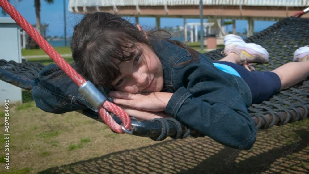 Child in a hammock. Happy little girl lies in a hammock in a summer park. Child in a hammock. Happy little girl lies in a hammock in a summer park.