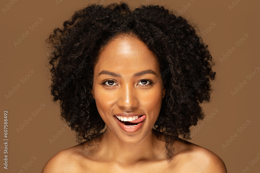 Playful naked black lady posing on brown background, closeup Playful naked black lady posing on brown background, closeup
